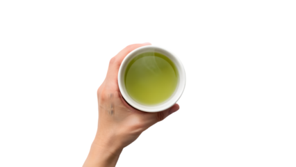 A hand holding a hot ceramic cup of green tea