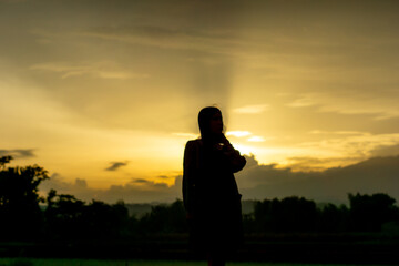 Silhouette of an Asian woman at sunset. Illustration of a lonely woman, an introverted woman. World Introvert Day.