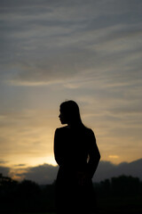 Silhouette of an Asian woman at sunset. Illustration of a lonely woman, an introverted woman. World Introvert Day.