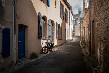 Motor bike on house wall in narrow street in french coastal town 2