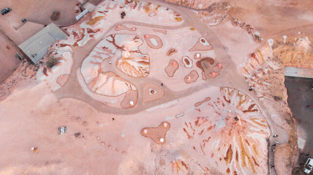 Aerial view of the ochre earth unfurls with abstract patterns and textures, creating a surreal landscape of muted colors and stark contrasts, Coober Pedy, South Australia, Australia.