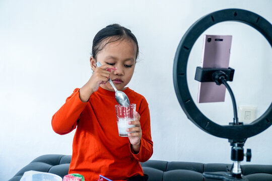 Little Asian Girl Practices Good Oral Hygiene With Toothbrush And Toothpaste