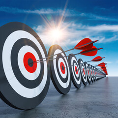 Motivational scene of arrows hitting a row of targets under a bright sky during daytime
