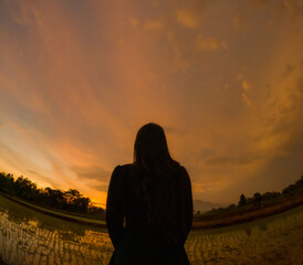 Fototapeta premium Silhouette of an Asian woman at sunset. Introvert illustration. World Introvert Day.