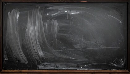 Smudged blackboard with wooden frame on dark wall, wiped clean but streaked with chalk residue.