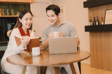 Happy Asian couple enjoying time together in their new home