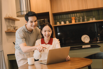 Happy Asian couple enjoying time together in their new home