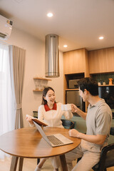 Happy Asian couple enjoying time together in their new home