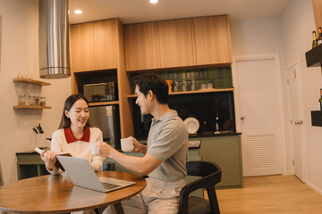 Obraz premium Happy Asian couple enjoying time together in their new home