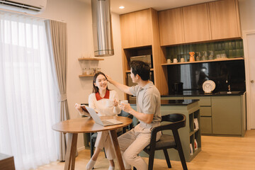 Happy Asian couple enjoying time together in their new home