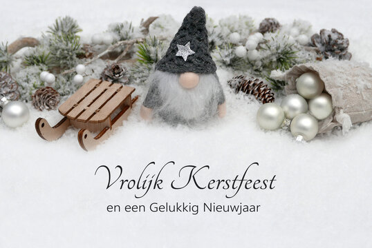 Kerstkaart: Kerstgroeten in het Nederlands met kerstballen, een slee en een elfje met dennentakken in de sneeuw. Vrolijk kerstfeest en een gelukkig nieuwjaar!