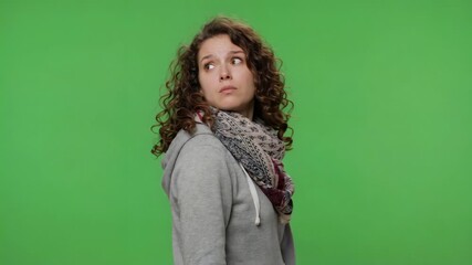 Confused young woman looking over shoulder shielding eyes searching for answers isolated on green screen background emotional concept 4k video footage
