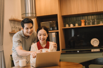 Happy Asian couple enjoying time together in their new home