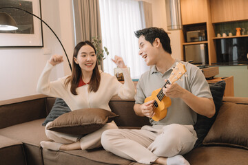 Happy Asian couple enjoying time together in their new home