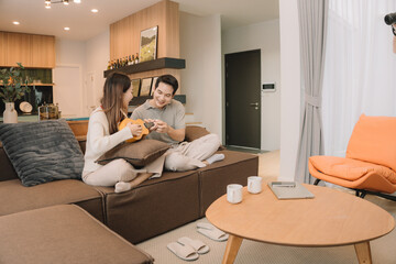 Happy Asian couple enjoying time together in their new home