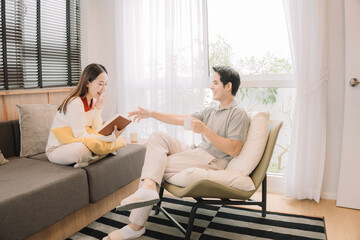 Happy Asian couple enjoying time together in their new home