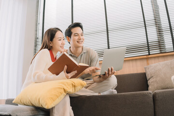 Happy Asian couple enjoying time together in their new home