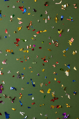 Colorful confetti on green background.