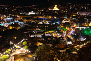 Aerial Night Panorama Of Tbilisi Cityscape With Peace Bridge And Sameba Cathedral © Vadim Volodin