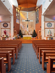 interior of a catholic church nave with Christmas trees on altar