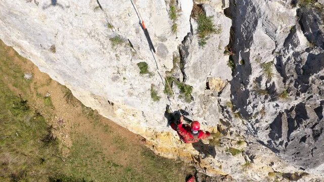  Flying near a mountain rescuer rappelling on a rocky wall with a drone