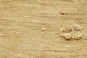 Old brown canvas fabric with a torn hole texture as background