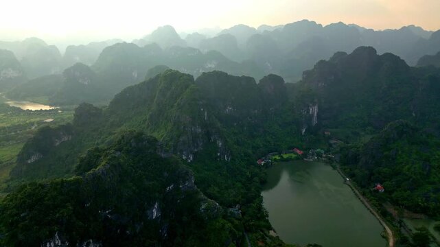 Aerial view of the lush, verdant mountains and serene lakes, creating a mesmerizing landscape of contrasting textures and tones, Hoa Lu, Ninh Binh, Vietnam.