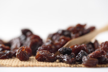 Dried dark raisins on a white background. A healthy snack