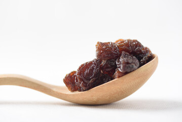 Dried dark raisins on a white background. A healthy snack