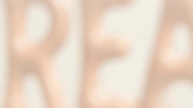 DREAM written in glossy, peach-colored, melted-looking letters on a light background.