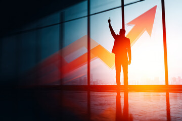 Silhouette of a businessman pointing upward against a backdrop of a rising arrow, symbolizing success and growth in business.