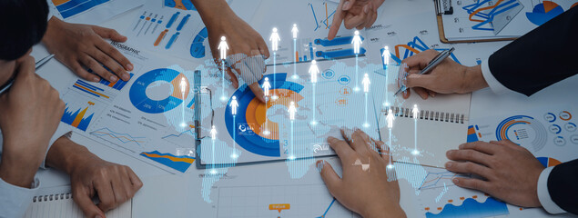 A diverse business team interacts with charts and graphs during a strategy meeting. They analyze data and collaborate to drive growth and improve performance in a modern office environment. Trope