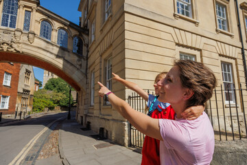 Fototapeta premium Mother and child point at a famous Bridge of Sighs, Oxford, UK
