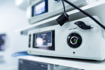 Obraz premium Close Up of Medical Light Source Device for Endoscopy. Detailed view of a white medical console featuring a light cable port and control buttons used for endoscopic or laparoscopic surgeries.