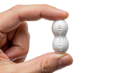 Tiny white object held between fingers against black