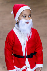 cute toddler dressed as santa claus walking outdoors