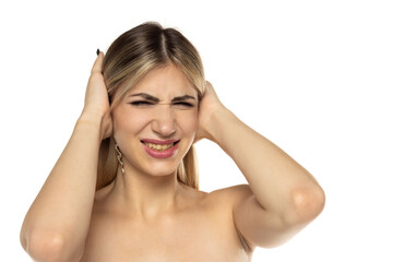 Naklejka premium Studio shot of a woman covering her ears with both hands, eyes closed and grimacing from loud noise, on a white background