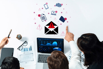 A group of professionals analyzing data on a laptop, surrounded by digital alerts and devices, showcasing teamwork and modern communication in a business setting. Gantry