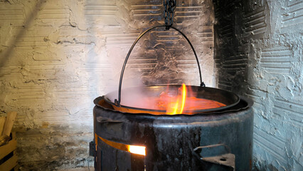 spicy tomato soup made of mixed meat cooked in a cauldron on an open fire