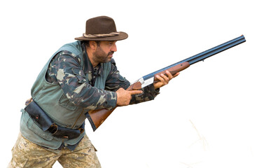 A man with a gun in his hands and an green vest on a pheasant hunt in a wooded area in cloudy weather. Hunter with dogs in search of game.