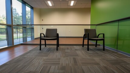 Two empty chairs in a room with a green wall and a wooden floor.