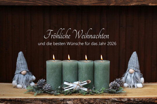 Weihnachtskarte: Brennenden Kerzen mit Weihnachtskugeln, Tannenzweigen und zwei Wichteln vor einer Holzwand. Auf dem Holz steht der Gru&szlig; Fr&ouml;liche Weihnachten und die besten W&uuml;nsche f&uuml;r das Jahr 2026.