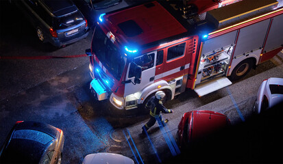 Fire truck at an urban emergency scene at night. Firefighter on duty. Concept of firefighting,...