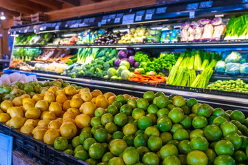 Fresh limes and lemons displayed in grocery store produce section