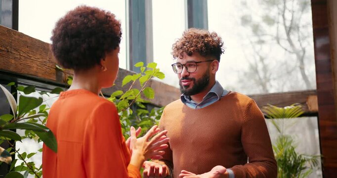 Smiling handsome middle eastern man wearing eyeglasses talking with beautiful woman