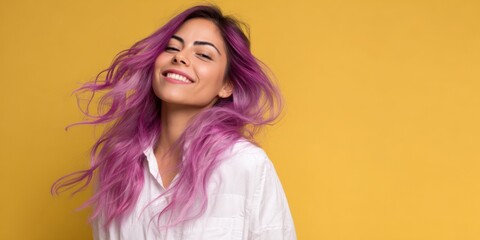 Smiling hispanic young female with long purple hair on yellow background