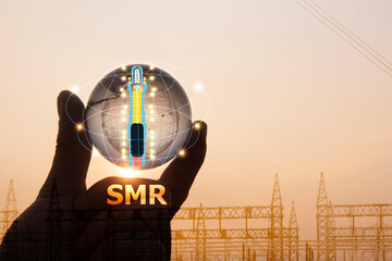 SMR text on glass world ,small nuclear power plant icon on a man's hand on natural background.Alternative energy for the future transition to a low-carbon electricity system concept.