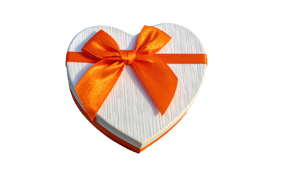 White heart-shaped box tied with a vibrant orange ribbon against a black background