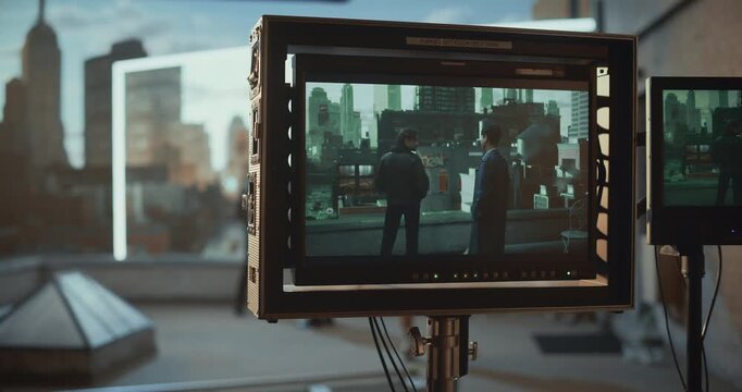 Film Crew Tracks a Rooftop Standoff on a Dolly, Monitoring Actors Through On-set Screens While Led Wall Renders Virtual City Scenery, Blending Practical Set, Cinematic Virtual Production.