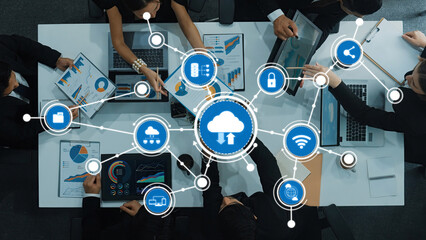 A modern business meeting showcasing professionals collaborating over data analytics and cloud computing, surrounded by charts and digital devices in a stylish office environment. Amity